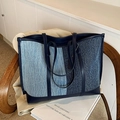 Bolso tote grande de mezclilla en contraste azul sobre un sillón de madera - Azul