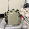 Light green nylon bucket bag with mesh side pocket and adjustable crossbody strap - Green