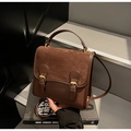 Detail of vintage brown textured leather backpack with retro metal buckle accents - Coffee