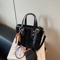 Black frosted star-embossed handbag with beaded charm and gold hardware accents - With Charm / Black
