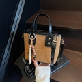 Brown bucket bag with black leather trim, star embossing and wooden bead charm - With Charm / Brown