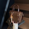 Dark brown leather bucket bag with star embossing and bohemian beaded charm accessory - With Charm / Coffee