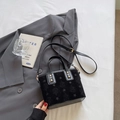 Black matte bucket bag with star print and gold studs on a grey suit jacket - Black (No Pendant)