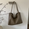 Detail der Textur der braunen geflochtenen Ledertasche und der langen Schultergurte - Braun