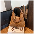 Dettaglio della texture in pelle scamosciata opaca sulla borsa marrone con ciondolo in legno - Marrone con ciondolo