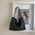 Close-up of black woven leather texture on a large capacity hobo tote shoulder bag - Black