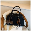 Zwarte canvas Boston tas met donut hanger en leren zonnebrillenzakje op een stoel - Met Hanger / Zwart met hanger
