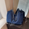 Deep blue denim tote bag with vintage chain-link woven strap in a premium lifestyle setting - Dark Blue