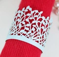 Close-up of light blue laser-cut napkin ring with intricate leaf pattern on red fabric - Pearl Pale Blue