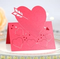 Detail of pink laser-cut heart place card with Cupid's arrow on elegant dinner plate - Pearlescent Red