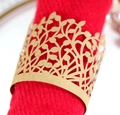 Macro detail of gold laser-cut leaf napkin ring on a red cloth for wedding decor - Kraft Paper