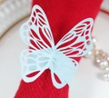Detail of light blue laser-cut butterfly paper napkin ring on a red cloth napkin - Pearl Pale Blue