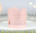 Macro shot of laser-cut pink paper wrap with intricate turkey pattern for cupcake or LED candle - Pink