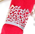 Macro shot of silver hollowed tree leaf napkin ring on a elegant red cloth napkin - Reflective Silver