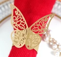 Macro shot of gold laser-cut butterfly napkin ring with intricate hollowed textures - Kraft Paper