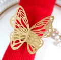 Rond de serviette papillon doré en papier avec découpe laser précise sur tissu rouge - Papier kraft