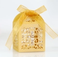 Makro-Detail des lasergeschnittenen Kreuzmusters auf goldener Hochzeitsbox mit Schleife - Gold