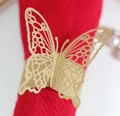 Vue macro de l'anneau de serviette papillon doré découpé au laser sur serviette rouge - Papier kraft