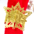 Golden hollow snowflake napkin ring made of metal on red textured fabric for Christmas - Reflective Gold