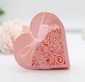 Detail of pink laser-cut heart favor box with intricate scrollwork and ribbon bow - Pink