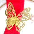 Exquisito servilletero de mariposa calada en acabado dorado sobre tela roja - Oro Reflectante