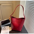 Detail of red bucket bag with wooden bead charm and faux leather texture on minimalist background - With Charm / Red
