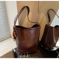 Close-up of deep brown tote bag with matte texture and ethnic beaded tassel detail - With Charm / Coffee