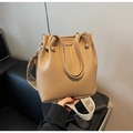 Detail der beigen Beuteltasche aus genarbtem Leder mit geometrischem Web-Schultergurt - Khaki