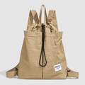 Close-up of khaki nylon drawstring backpack with signature woven label and fabric texture - Khaki