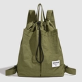 Detail of army green nylon drawstring backpack featuring a branded woven label and texture - Green