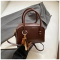 Detail einer braunen Bowling-Tasche aus Wachsleder mit Vintage-Holzperlen-Anhänger - Mit Anhänger / Braun
