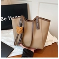 Minimalist beige pebble leather tote bag with dark brown straps and bear pendant - Khaki