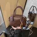 Chic dark brown faux leather bowling bag with twin handles and beaded charm detail - With Charm / Brown