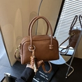 Dark brown leather bowling handbag with a colorful bead charm and crossbody strap - With Charm / Brown