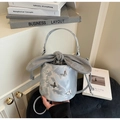 Detail of blue bucket bag with silver butterfly charms and drawstring bow closure - Silver