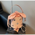Detailed shot of pink bucket bag with 3D metal butterfly and cute rabbit ear drawstring - Pink