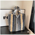 Close-up of fluffy striped faux fur tote bag with metal drawstring and thick soft texture - Blue