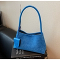 Detailed macro view of royal blue suede tote bag texture and matching round pendant charm - Blue