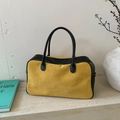 Detalle del bolso Boston amarillo y negro sobre mármol con textura de ante suave - Amarillo