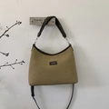 Detail of suede crossbody bag with leather trim hanging on a minimalist wall - Khaki Large
