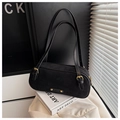 Detail of black suede Boston bag with gold hardware resting on an Art Deco book - Black