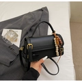 Detail of a black leather handbag with gold buckle and ethnic beaded tassel charm - Black (With Charm)