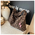 Detail of leopard print tote bag with pink leather hooks and textured fabric finish - Brown