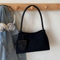 Minimalist black matte shoulder bag with a cylindrical handle and stylish charm - Black