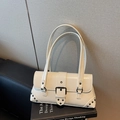 Cream white vintage underarm bag with metal buckle and stud details on design book - Off White