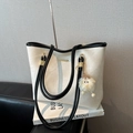 Off-white leather tote bag with black contrast straps and a yellow plush monster charm - White with Pendant