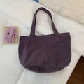 Detailed close-up of deep purple canvas tote bag featuring thick woven texture and wide strap - Purple