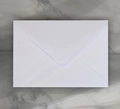 Classic white matte paper envelope with a V-flap design on a gray marble surface - Western Long Pearlescent / White