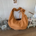 Close-up of caramel suede hobo bag with pleated handle and drawstring details - Brown