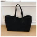 Close-up of black suede tote bag with dual straps on a light wood floor background - Black